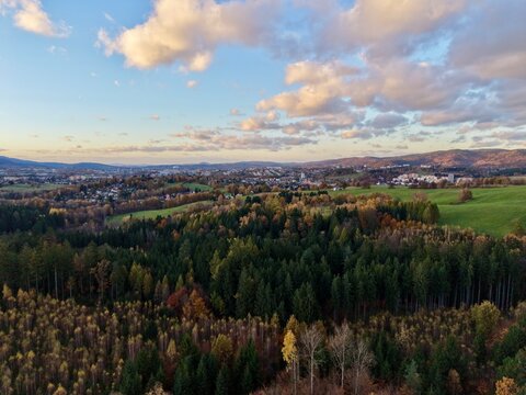 aerial scenic panorama, sunshine over hills and fields, flying high above lush land and distant settlements