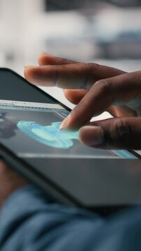 Vertical video Close up of data center engineer using AI software on tablet to optimize performance and forecast issues. Programmer integrating artificial intelligence automation in data center