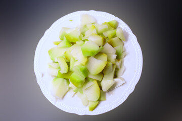 Fresh Chopped Green Chayote Squash Pieces on White Plate &mdash; Healthy Food Photography