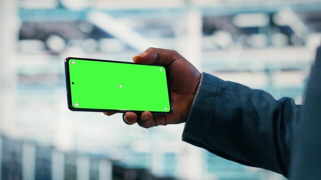 Green screen smartphone used by server farm worker to optimize electronics. Data center admin using chroma key phone to monitor system performance and fix bottlenecks, camera B