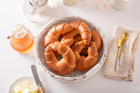 Golden and hot croissants with honey for breakfast.