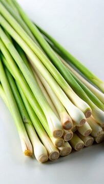 A closeup of fresh lemongrass stalks on a pristine white background The stalks are vibrant green with crisp leaves that appear fresh and alive Thei