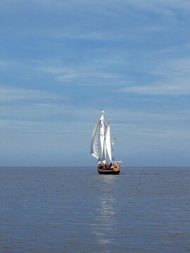 Traditional two-masted wooden sailboat sailing on the lake. Classic boat design and maritime heritage in Poland.