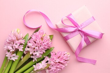 Fototapeta premium Beautiful hyacinth flowers and gift box on pink background, flat lay