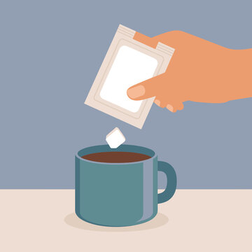 Hand holding tea bag over a blue mug on table indoors