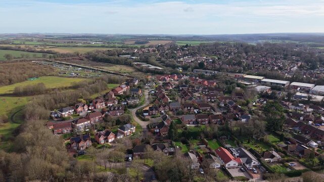 Aerial drone footage showcasing the market town of Whitchurch in Hampshire, England. Elevated panoramic views reveal residential neighborhoods