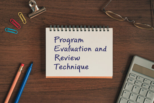 Corporate and management concept of Program Evaluation and Review Technique represented on notebook with pen, clips, glasses. Professional business leadership and operations.