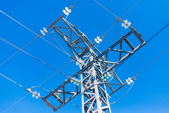 Electric Transmission Tower Viewed From Below Against Blue Sky