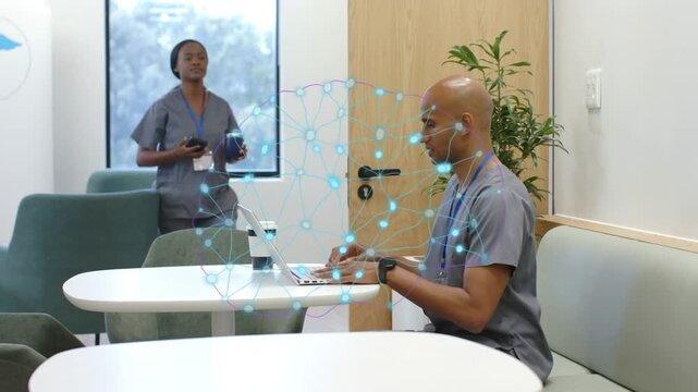 Medical woman walking left bringing drinks and phone approaching man typing laptop overlay hovering