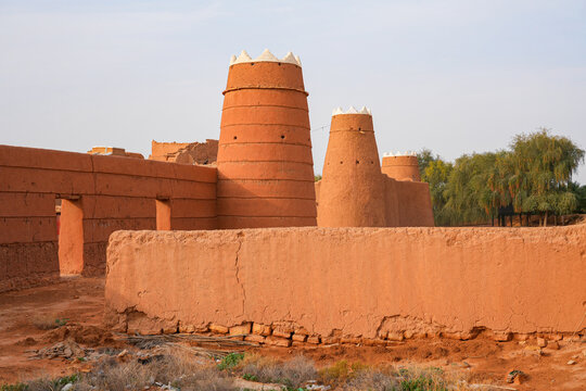 Traditional Najdi mud brick watchtower with white crenelations in Shaqra, a historical desert village in Saudi Arabia