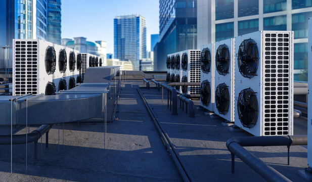Rooftop HVAC units and ventilation systems on modern city building. Industrial air conditioning infrastructure in urban commercial district.