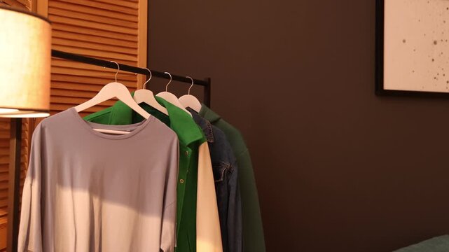 Rack with stylish clothes in teenager's room, camera moving in