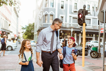 Obraz premium Father walking with son and daughter at city crosswalk