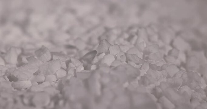 white coarse solid salt that is used in dishwashers to improve and soften water, white coarse crystals of special salt for dishwashers