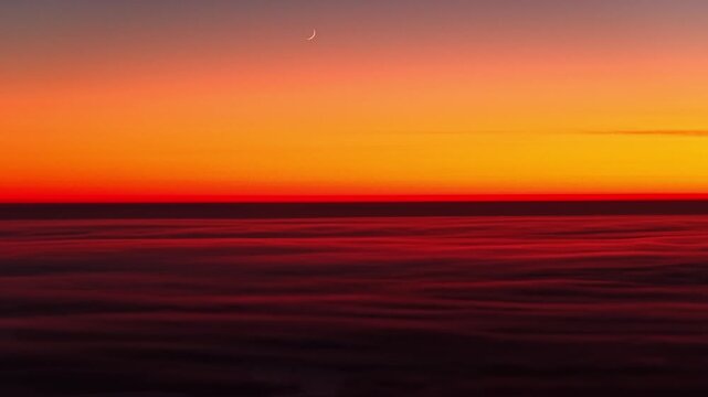 Waxing crescent moon on dazzling vivid sunset, flyover fluffy clouds in Latvia