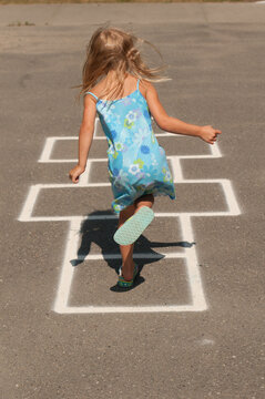 Canada, BC, Vancouver.  Young girl (age 8) playing hopscotch.  