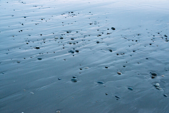 USA, WA, Queets.  Small pebbles on the sand on the west coast of the Olympic Peninsula on the shore of the Pacific Ocean.