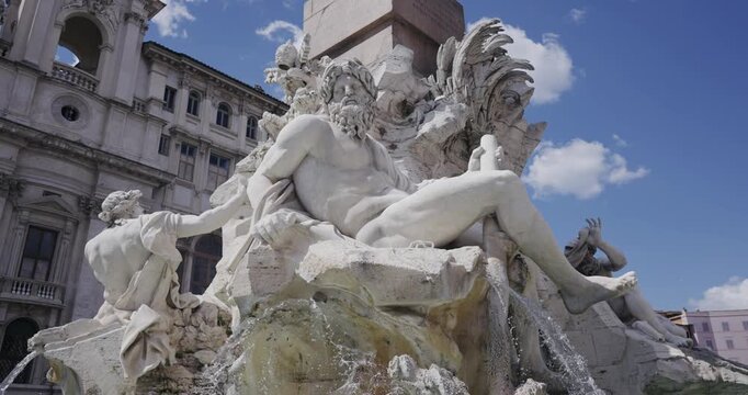 Fountain of the Four Rivers (Fontana dei Quattro Fiumi) on Navona square in Rome, Italy in front of church sant Agnese in Agone, Water flow in slow motion