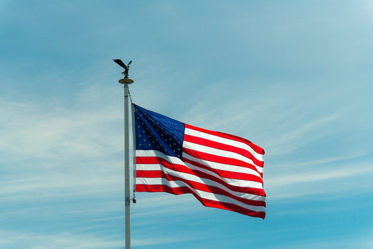 USA, WA, Oak Harbour.  US flag flowing in the breeze over Whidbey Island