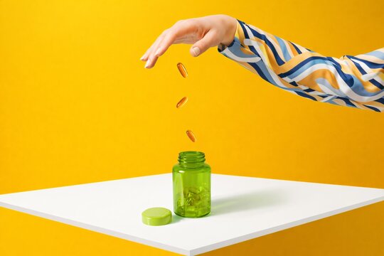 A bright health‑themed image showing softgel capsules being placed into a green bottle against a yellow background, ideal for wellness, nutrition, supplements, and global health awareness events.