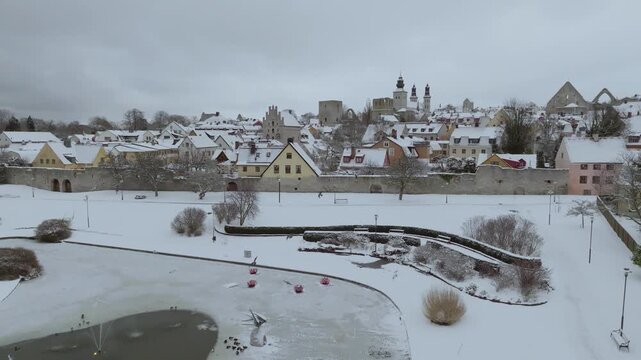 Winter Aerial of Almedalen and Visby Old Town with its City Wall with Flying Birds, Gotland Sweden
