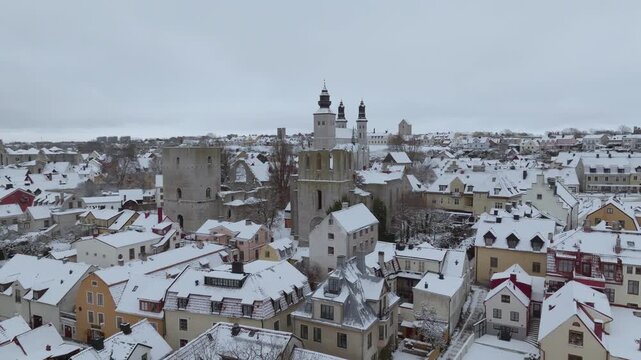 Winter Drone Pullback Revealing Visby Old Town, Cathedral, Ruins and Almedalen in Snow, Gotland Sweden