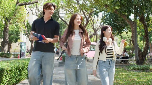 Three Asian University Students Walking and Talking on Sunny Campus Park