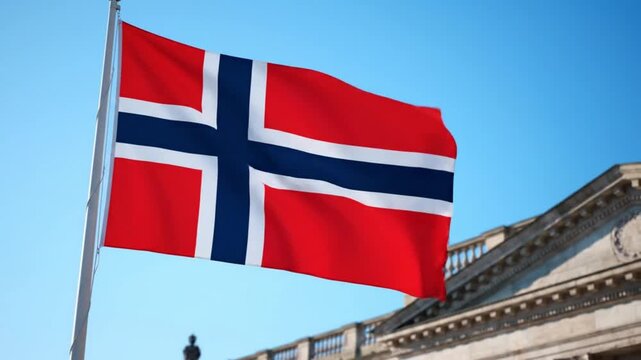 Norwegian flag waving on a pole in front of a building with a clear blue sky