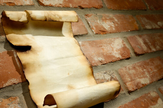 Old scroll of parchment paper letter on a brick wall background