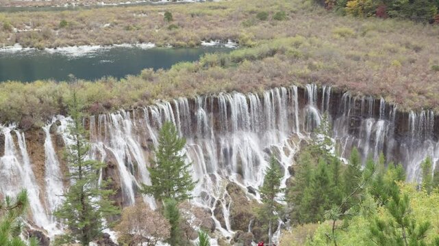 High angle view of Nuorilang Falls or Nuorilang waterfall. Beautiful landscape of Jiuzhaigou National Park in autumn in Sichuan Province China. 4K slow motion footage travel concept.