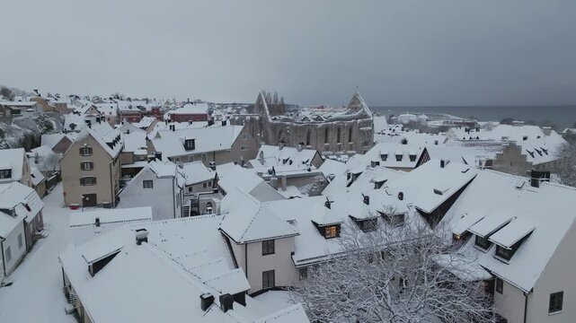 Aerial Flight Toward St Karins Ruin Over Snow Covered Visby Old Town in Winter, Gotland Sweden
