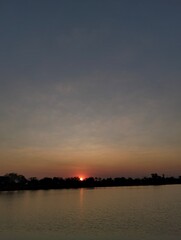 Fototapeta premium sunset light on sky behind the trees in the lakeside 