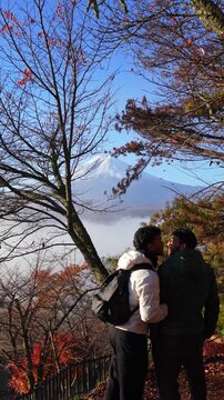 LGBTQ couple kissing with scenic Mount Fuji view