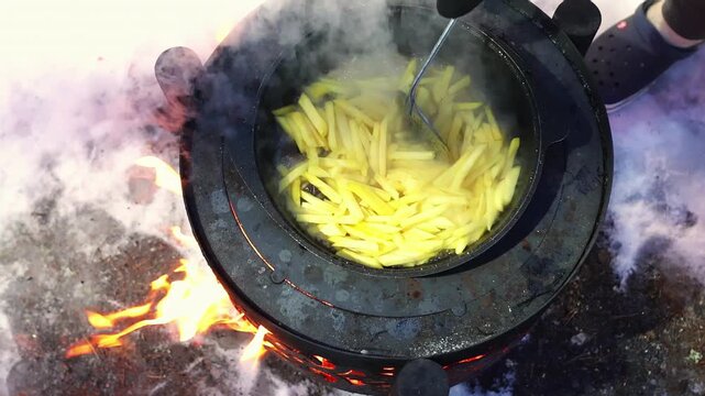 Pan full of hot food emitting steam in snowy landscape. Rustic cuisine concept and winter travel lifestyle. Metal stove top with steaming dish. Expedition cooking and cold climate atmosphere.