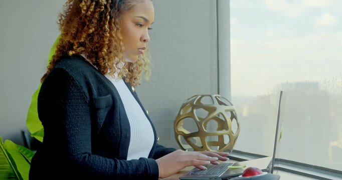 Woman Using Laptop by Window in Office