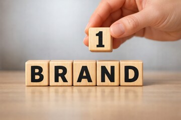 Building the Brand: A hand strategically positions a number one wooden block, adding an element of focus. The arrangement emphasizes concepts of identity and distinction, on a table.
