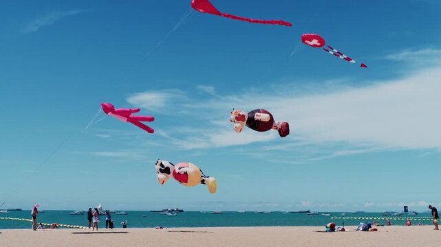 Pattaya, Thailand - Feb 28 2026: Colorful kites flying over Pattaya Beach during International Kite Festival