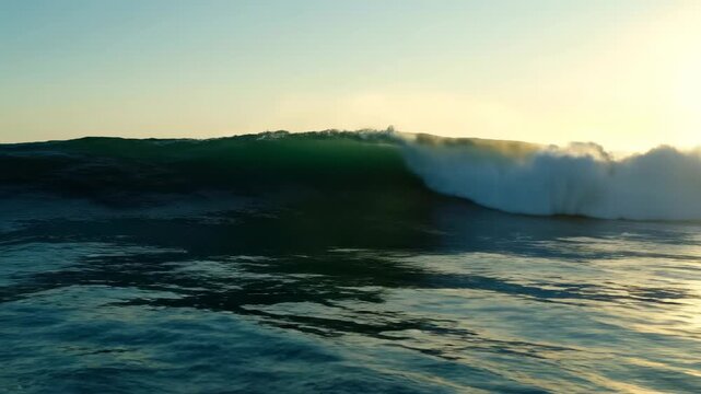 A large, curling ocean wave at sunrise, captured in a scenic seascape