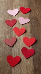 Obraz premium Red and purple wooden heart shapes arranged on rustic wooden background, symbol of love and Valentine theme.