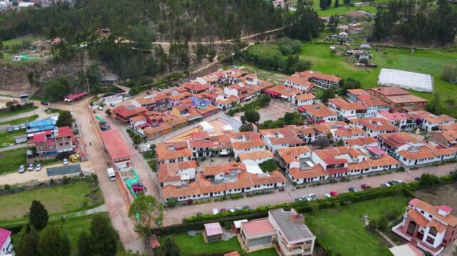 Aerial shot of colorful rooftops and green landscapes in Duitama, Colombia, showcasing a small town atmosphere.