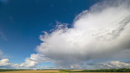 A Beautiful, Dramatic Cloudscape and rainbow Set Against a Clear Blue Sky on a Bright Summer Day