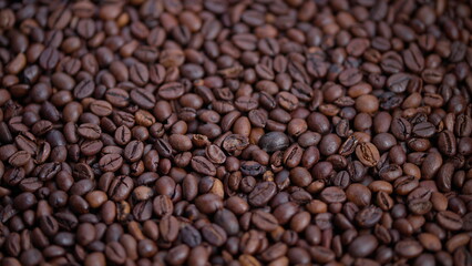 Fototapeta premium Dark roasted beans, Rich aroma and detailed texture of roasted coffee beans, Cozy cafe scene showcasing shiny roasted beans with subtle oil sheen and detailed creases
