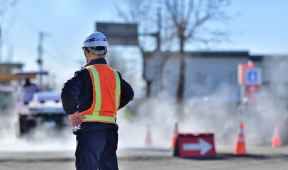 街路舗装工事を監督する工事部長