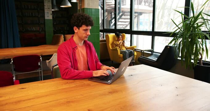 Angry, sad man businessman using laptop, working in modern office, copywriter typing on keyboard