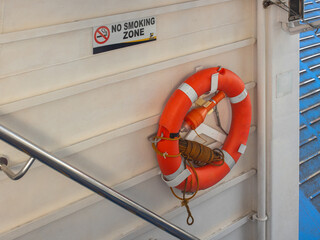 Safety Equipment on Ship Deck: Orange Lifebuoy and No Smoking Zone Sign