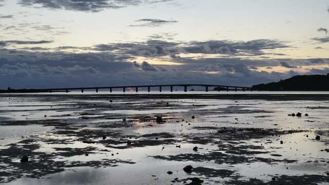 Peaceful morning at Hamahiga: A white heron walking on mirror-like tidal flats at sunrise, Okinawa.