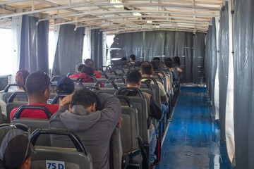 Passengers Seated on the Open Upper Deck of a Ferry During a Sea Voyage