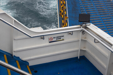 No Smoking Zone Sign on Ship Deck with Sea Waves and Ferry Infrastructure