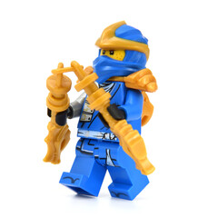 Fototapeta premium Editorial illustrative image of lego minifigure of blue ninja Jaywith golden blades weapon isolated on white. Jubilee 15 years of lego Ninjago.