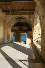 Naklejka premium A tranquil view from an ancient stone building overlooking the azure sea in the midday sun.